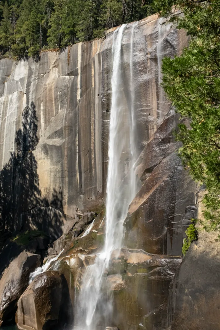 Waterfall pouring down a streaked granite cliff
